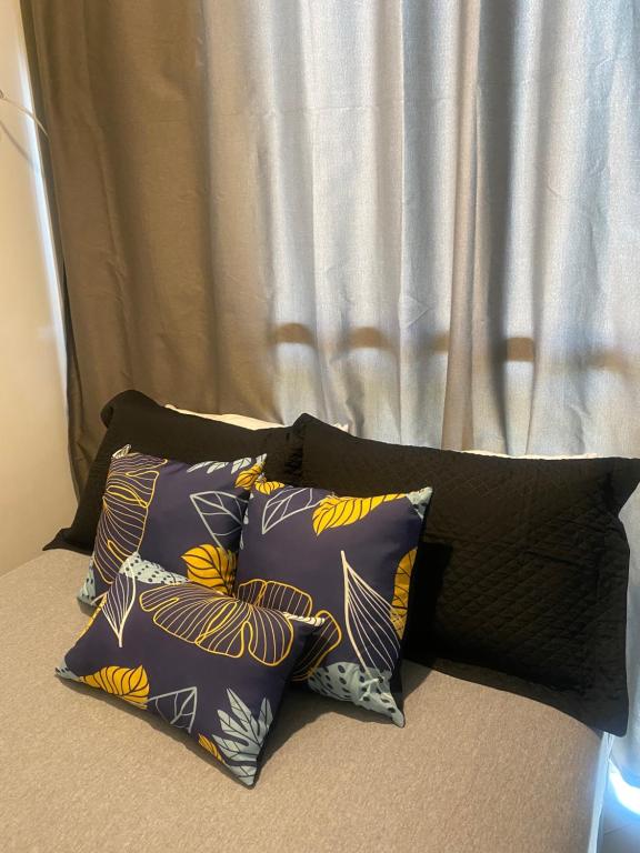 a group of pillows on a bed with a curtain at Reserva do Sahy-Mangaratiba Condado Loft Sol & Sal in Mangaratiba