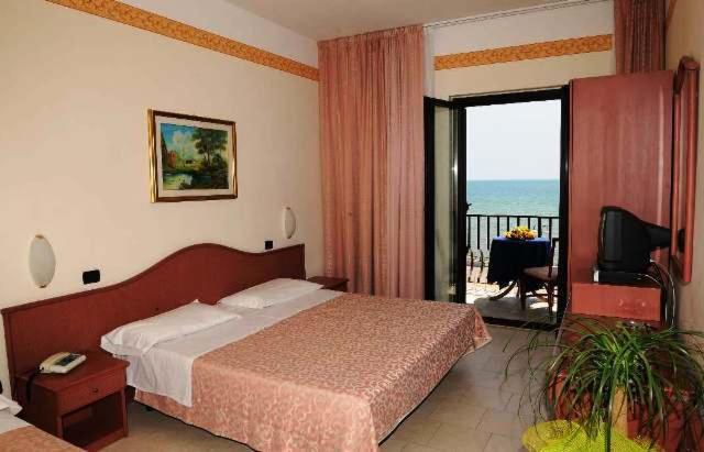 a bedroom with a bed and a view of the ocean at Hotel Panorama Del Golfo in Manfredonia