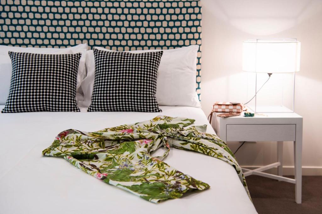 a white bed with a green blanket on top of it at Kirsten Accommodation Mudgee in Mudgee