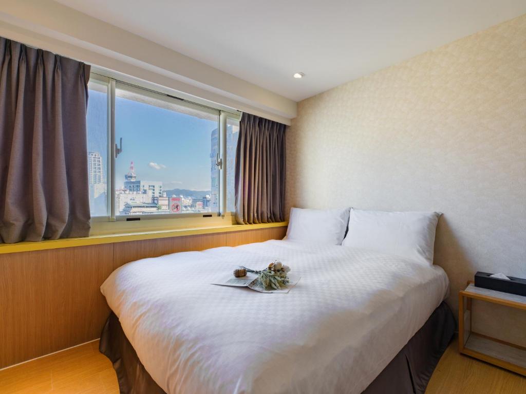 a hotel room with a large bed with a window at LaVita Hotel in Taipei
