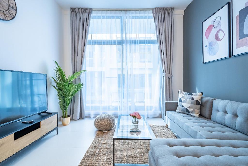 a living room with a couch and a tv at Primestay - 1BR in Prime Views Al Meydan in Dubai