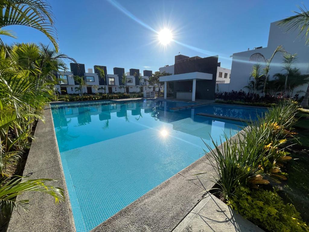 a large swimming pool in a resort with palm trees at Casa vacacional familiar in Naranjo