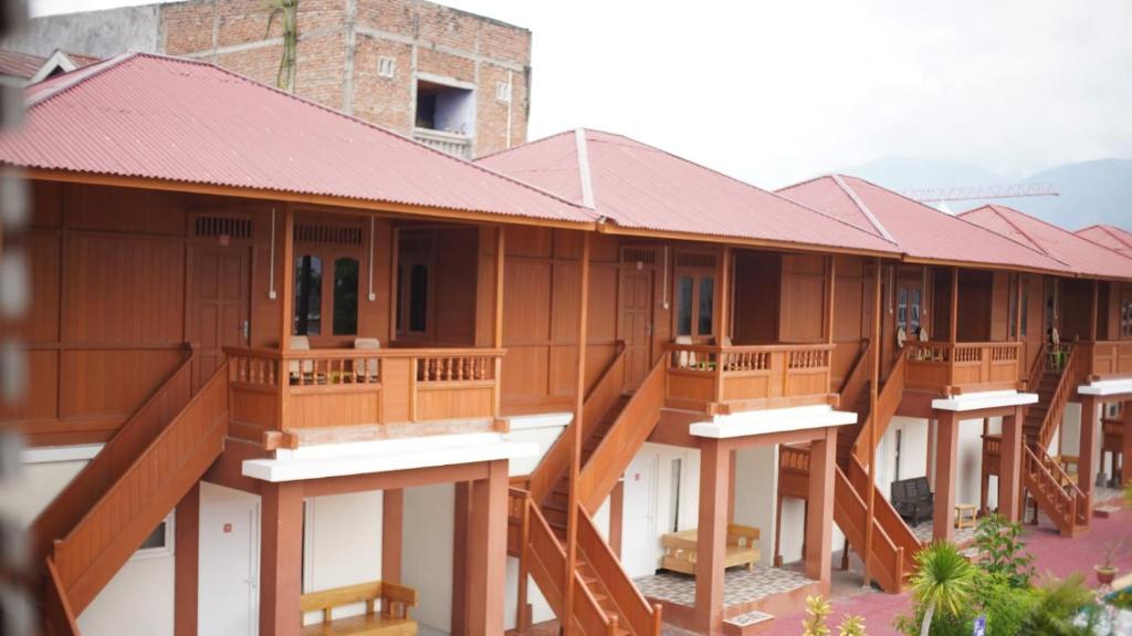 une rangée de bâtiments en bois avec balcon dans l'établissement GRANADA INN PALU, à Palu