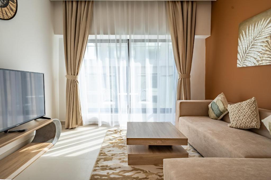 a living room with a couch and a large window at Primestay - 1BR in Prime Views in Al Meydan in Dubai