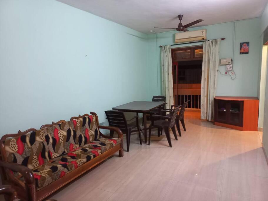 een eetkamer met stoelen en een tafel en een plafondventilator bij 2 Bhk Holiday home near Panjim city & Beaches in Panaji