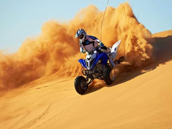 a person riding a dirt bike in the desert at Desert Malra Camp in Jaisalmer