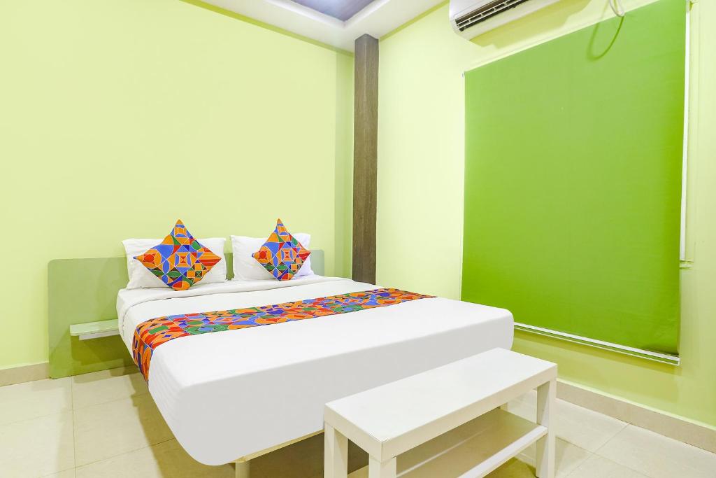 uma cama branca num quarto com uma parede verde em FabExpress Airport Stay Inn em Hyderabad