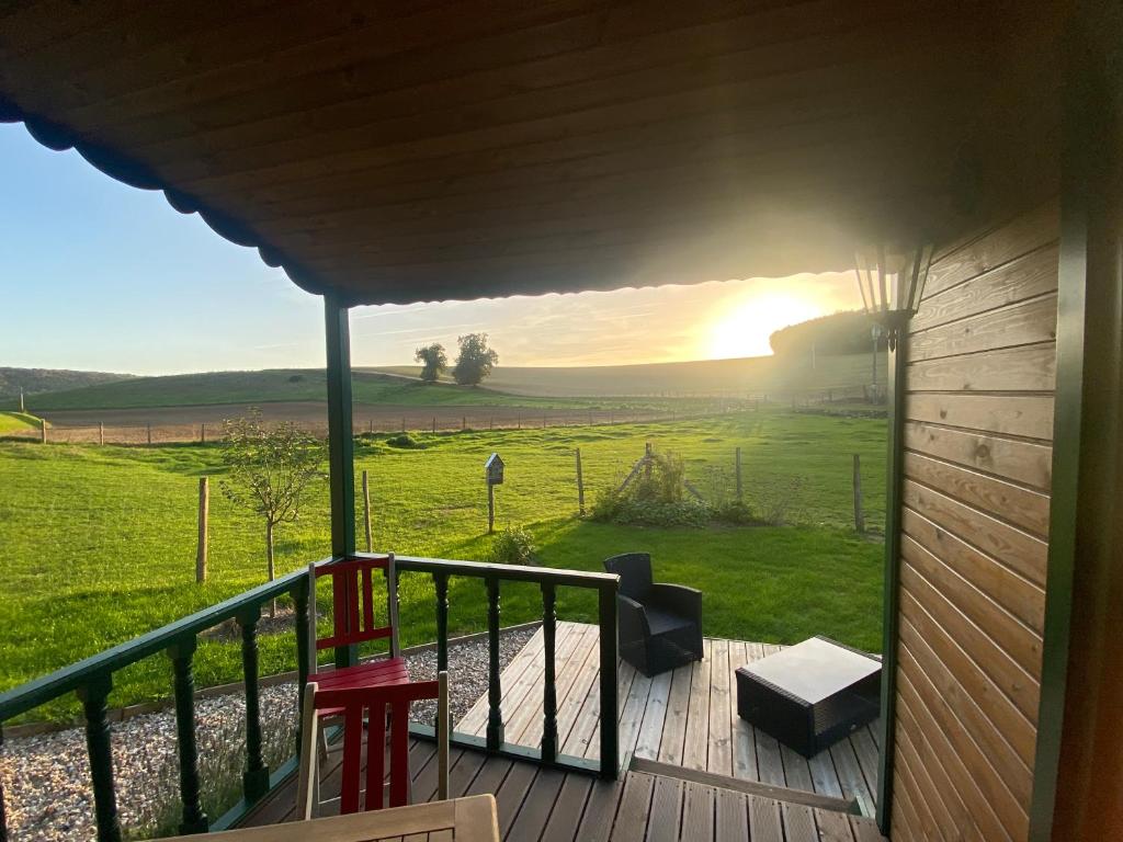 a balcony with a view of a field and the sunset at La roulotte de bonneval in Charleval