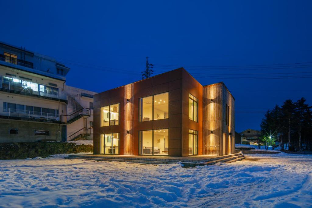 a large building in the snow at night at Bluebird Apartments by The Hakuba Collection in Hakuba