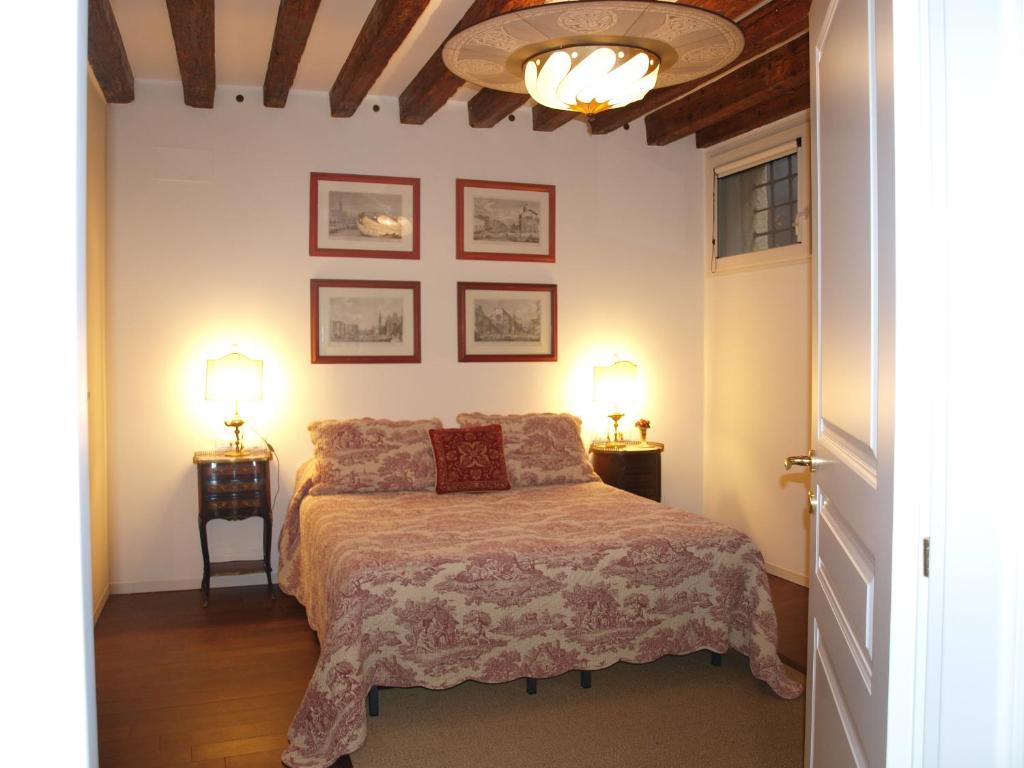 um quarto com uma cama com duas mesas de cabeceira e dois candeeiros em Al pozzo dei Scoacamini, 100 m from San Marco, ground floor em Veneza