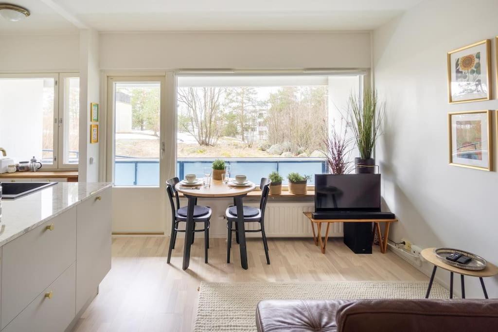 a kitchen and living room with a table and chairs at Eastend Pearl - Studio with great kitchen - subway and shops near in Helsinki