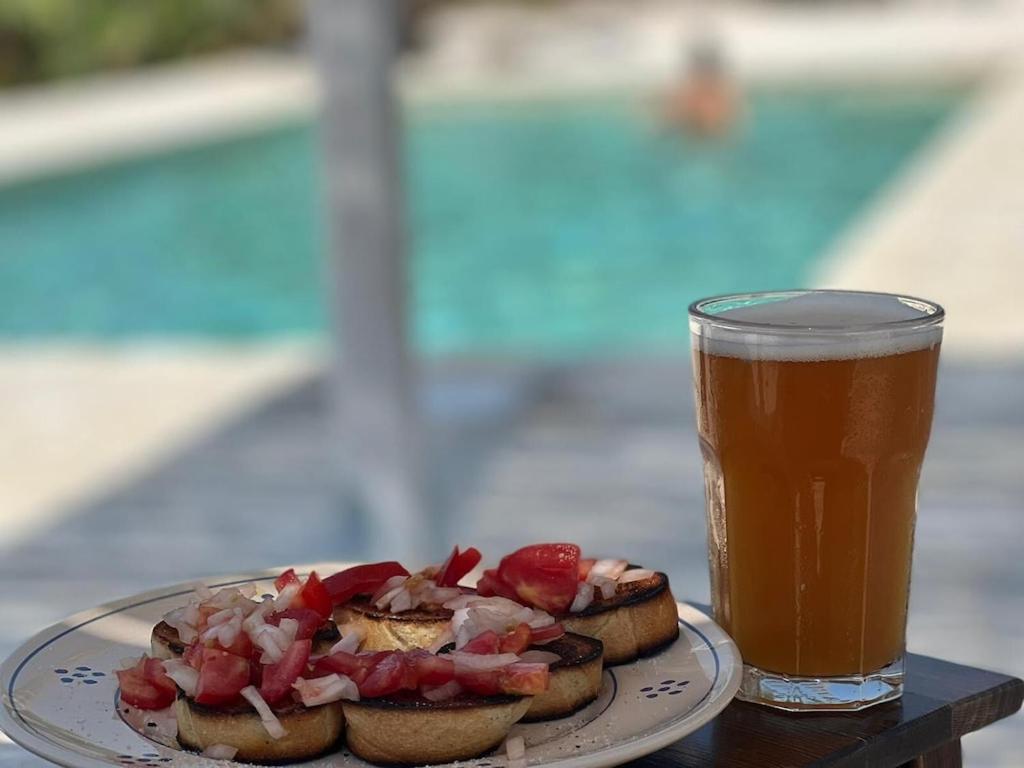 um prato com dois cachorros quentes e uma bebida na mesa em Casa Giuliveto - Charmantes Ferienhaus mit Privatpool in Olivenhain em Ostuni