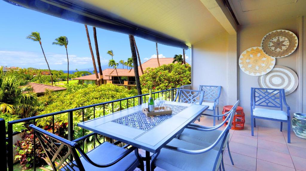 una mesa y sillas en un balcón con vistas en Maui Eldorado B200-Large lanai w/ocean/golf course views, en Lahaina