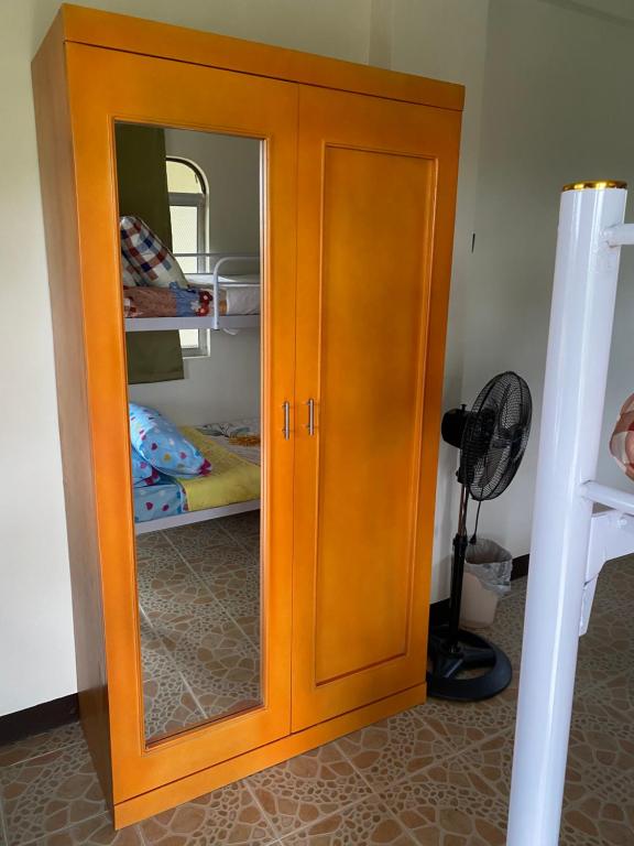 einen Holzschrank mit einem Spiegel im Schlafzimmer in der Unterkunft Palanca Lodging Home in Candelaria