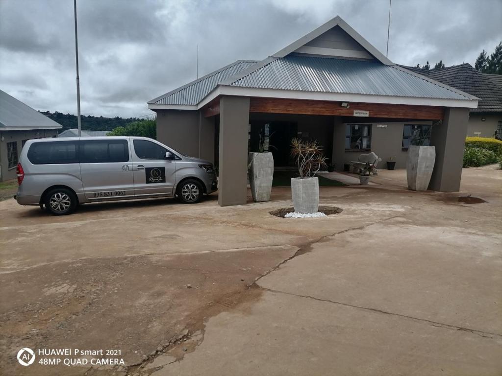Nongoma Lodge & Inn CC في Nongoma: سيارة فان متوقفة أمام منزل