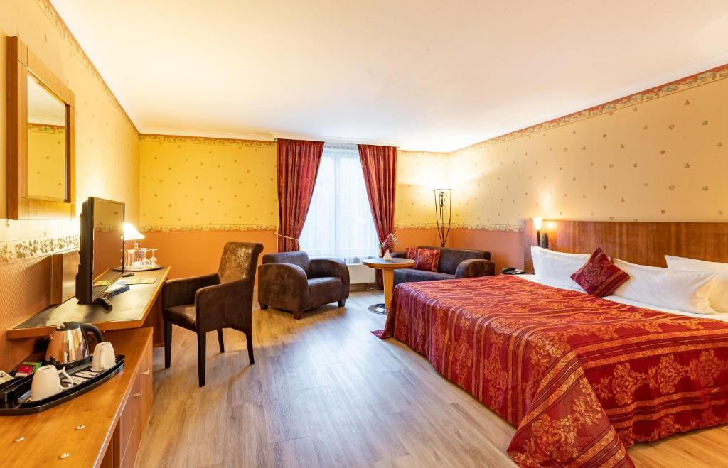 a hotel room with a bed and a desk at Parkhotel Görlitz in Görlitz