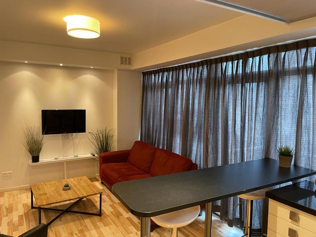 uma sala de estar com um sofá e uma mesa em City Hotel Appartement Tilburg em Tilburgo