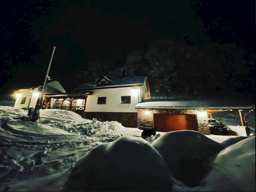 a house is covered in snow at night at Chata Klinger in Banská Štiavnica