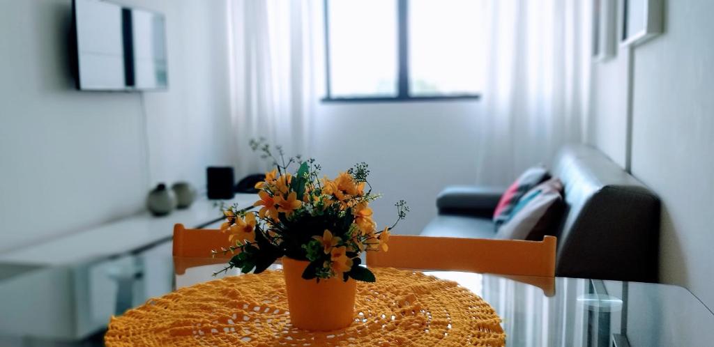 um vaso com flores numa mesa num quarto em Melhor localização em Boa Viagem! em Recife
