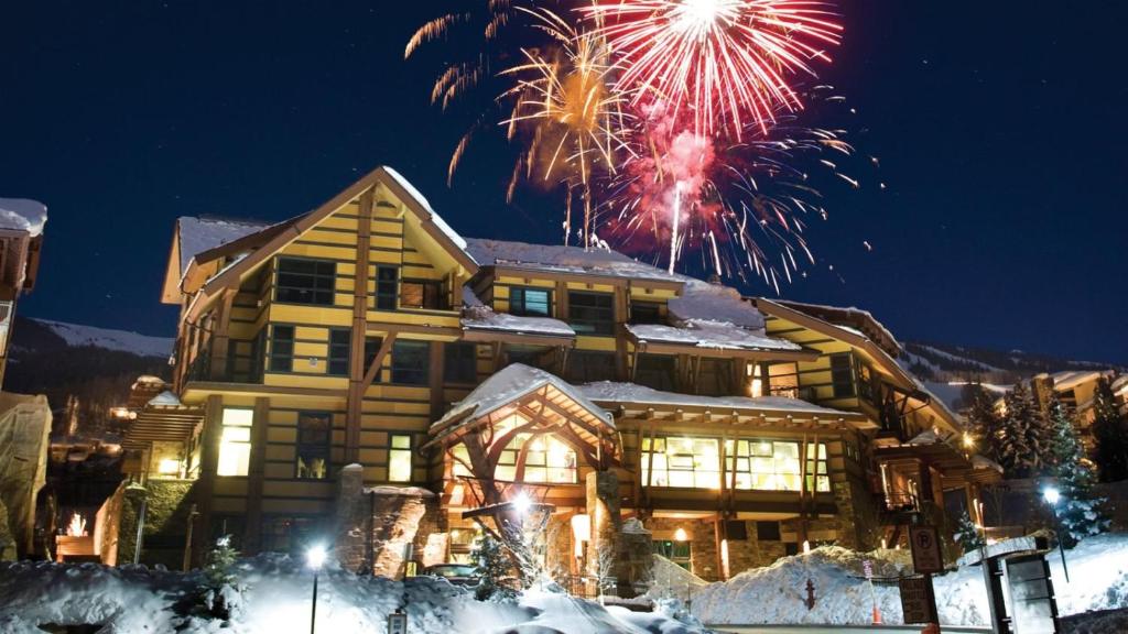 Ein Haus mit Feuerwerk, das im Himmel explodiert. in der Unterkunft Luxury Ski In, Ski Out 3 Bedroom Mountain Resort Vacation Rental In The Heart Of Snowmass Base Village in Aspen