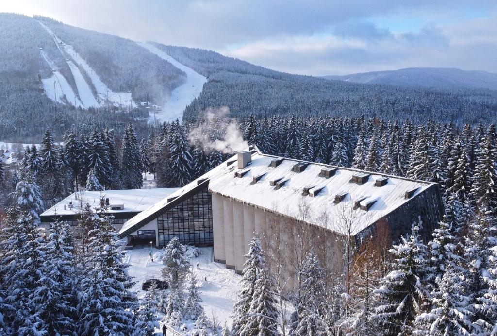 a building in the middle of a snow covered mountain at Wellness Hotel Svornost in Harrachov