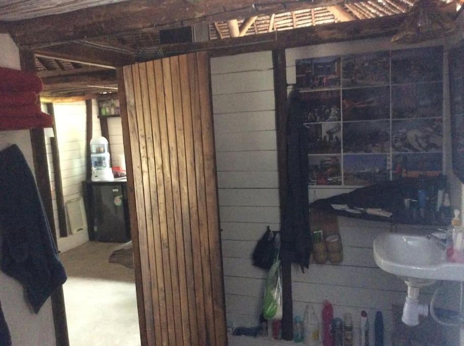 Cette chambre comprend une salle de bains avec lavabo et une chambre avec lavabo. dans l'établissement Beach front Cottage, à Mahambo