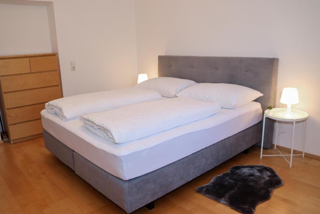 Appartement Bärhof في إنسبروك: سرير بملاءات بيضاء و اللوح الأمامي في غرفة النوم