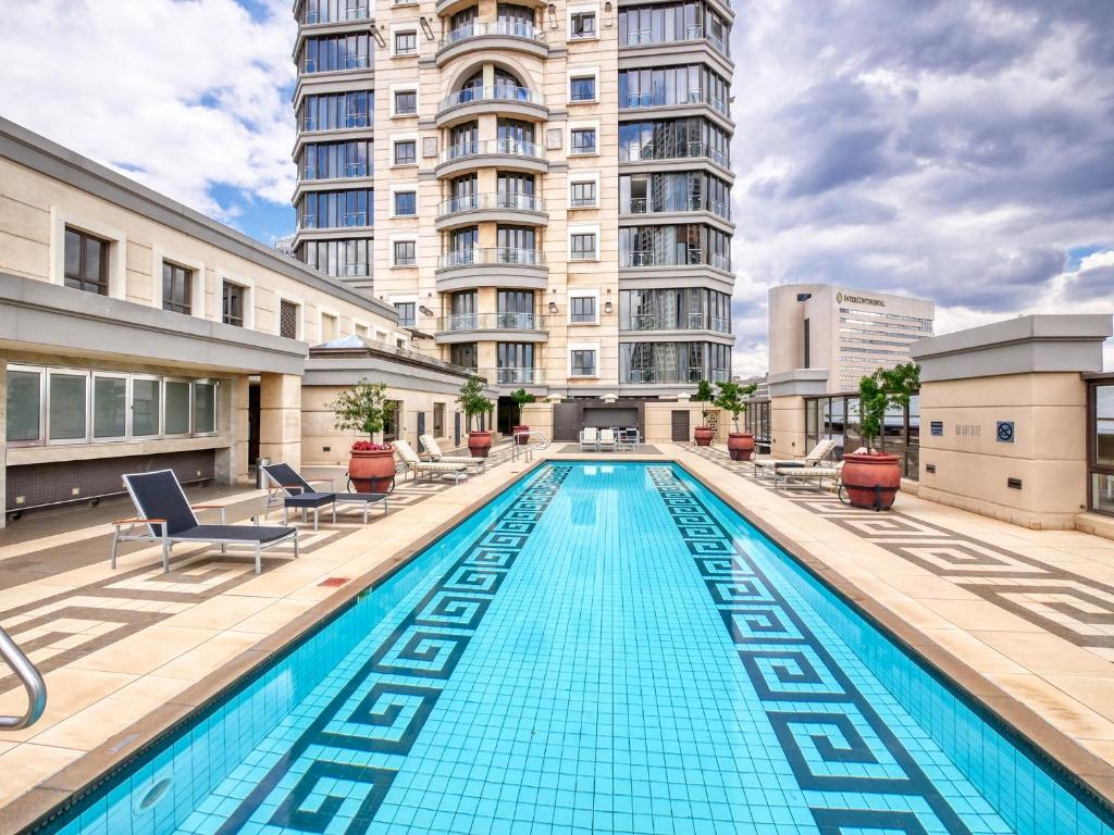 a large swimming pool in front of a building at Apartment at Michelangelo Towers in Johannesburg