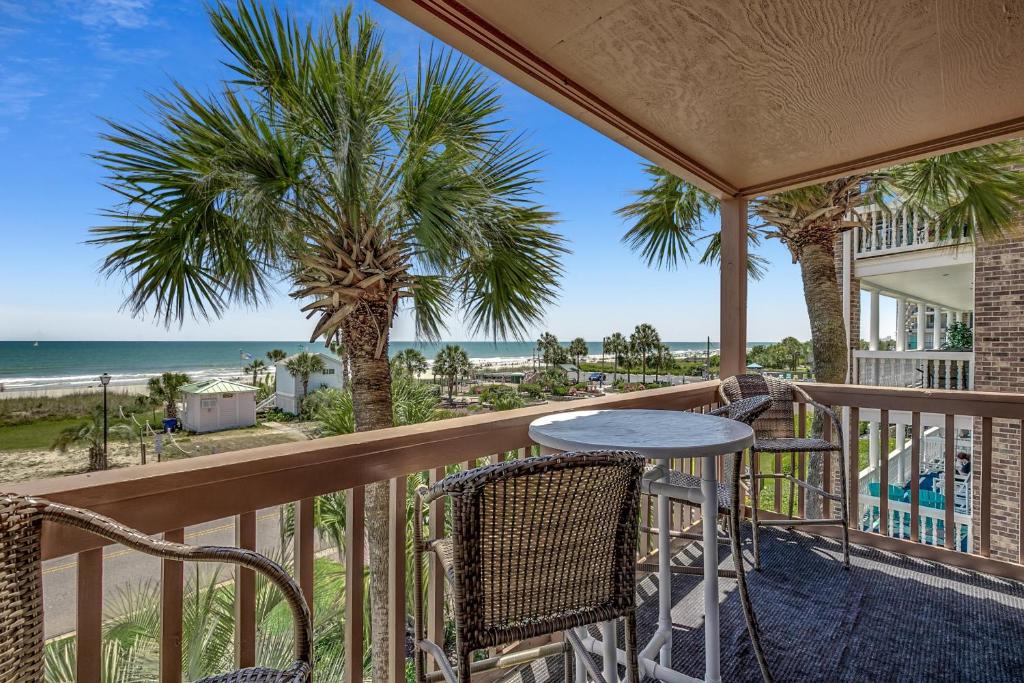 a balcony with a table and chairs and the beach at Anchorage II B02 in Myrtle Beach