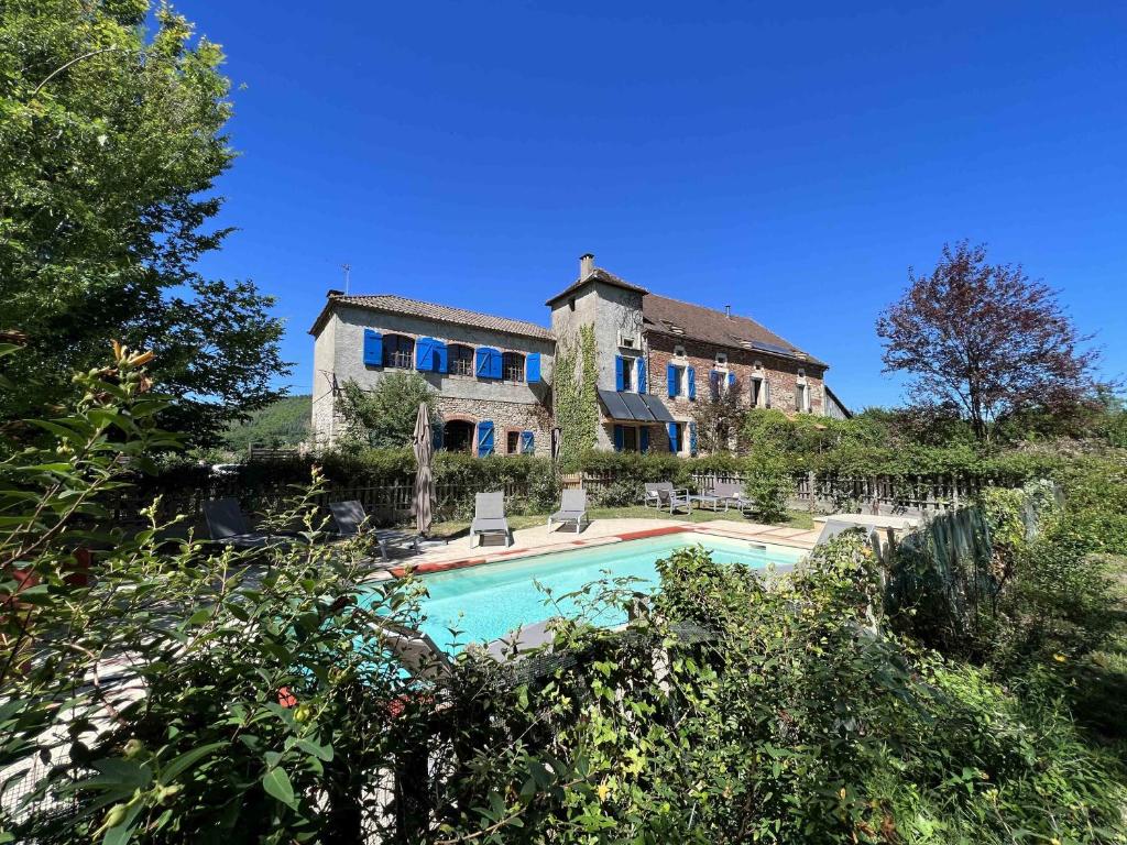 a large house with a swimming pool in front of it at Gite la Tuilerie 46 in Tour-de-Faure