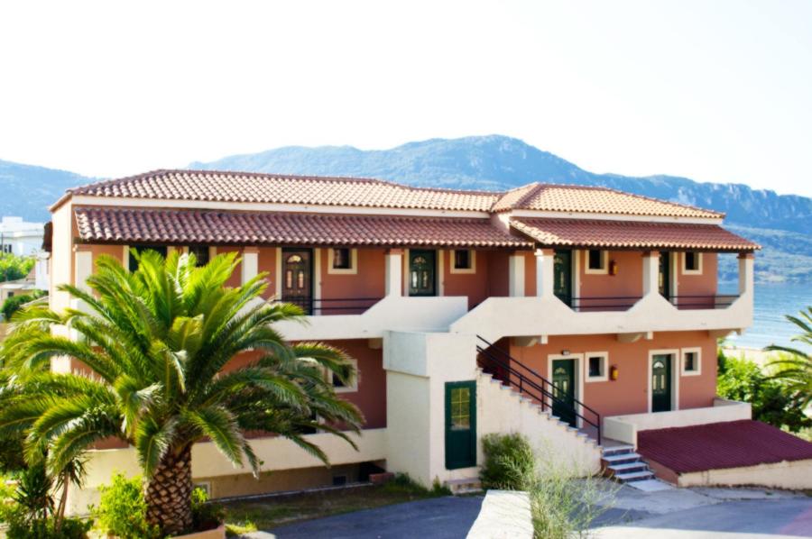 une maison avec un palmier en face dans l'établissement Dixtia Apartments, à Agios Georgios Pagon