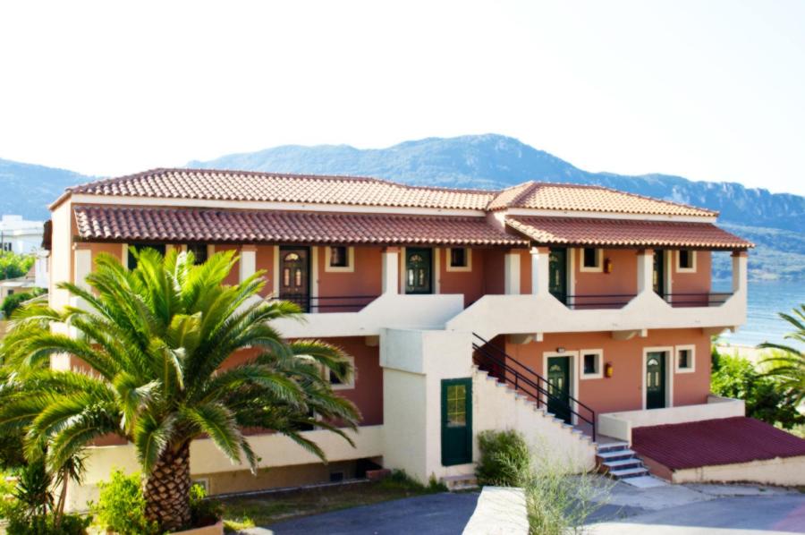 a house with a palm tree in front of it at Dixtia Apartments in Agios Georgios Pagon