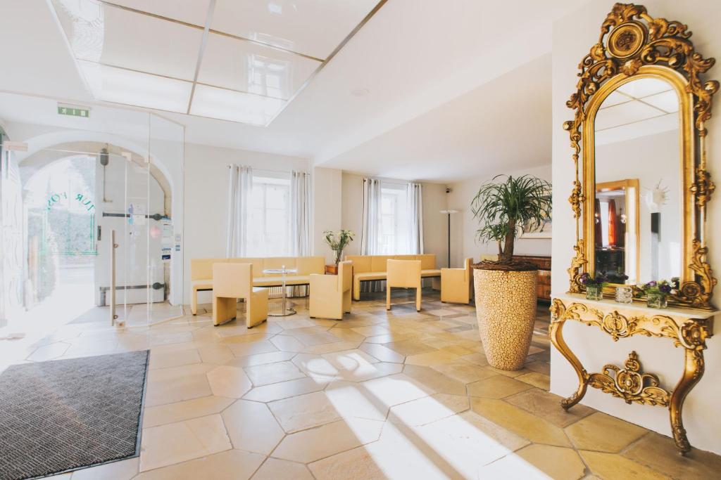 a living room with a mirror and a table and chairs at Hotel Landgasthof Zur Post in Mengkofen