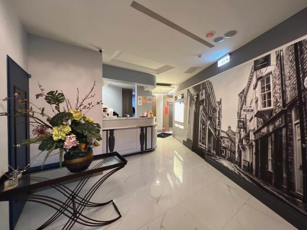台北的住宿－日月星商旅，走廊上设有黑白墙,桌子上有一束花