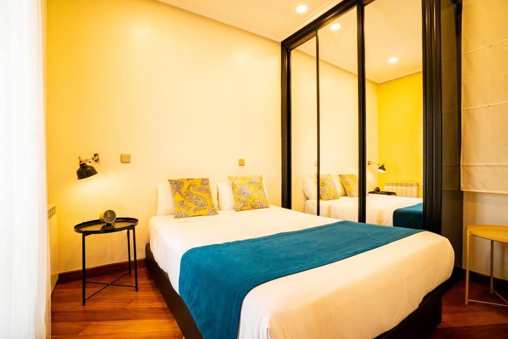 - une chambre d'hôtel avec un lit et un miroir dans l'établissement Smartr Madrid La Latina, à Madrid