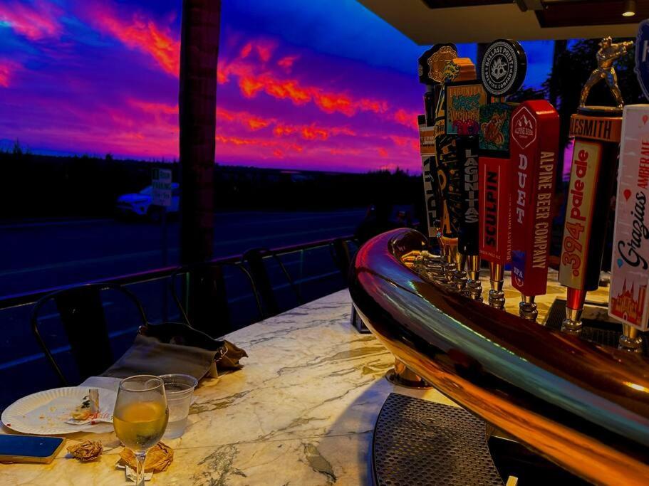 un tavolo con un bicchiere di vino su un balcone con un tramonto di Del Mar townhouse by Torrey Pines Beach a San Diego