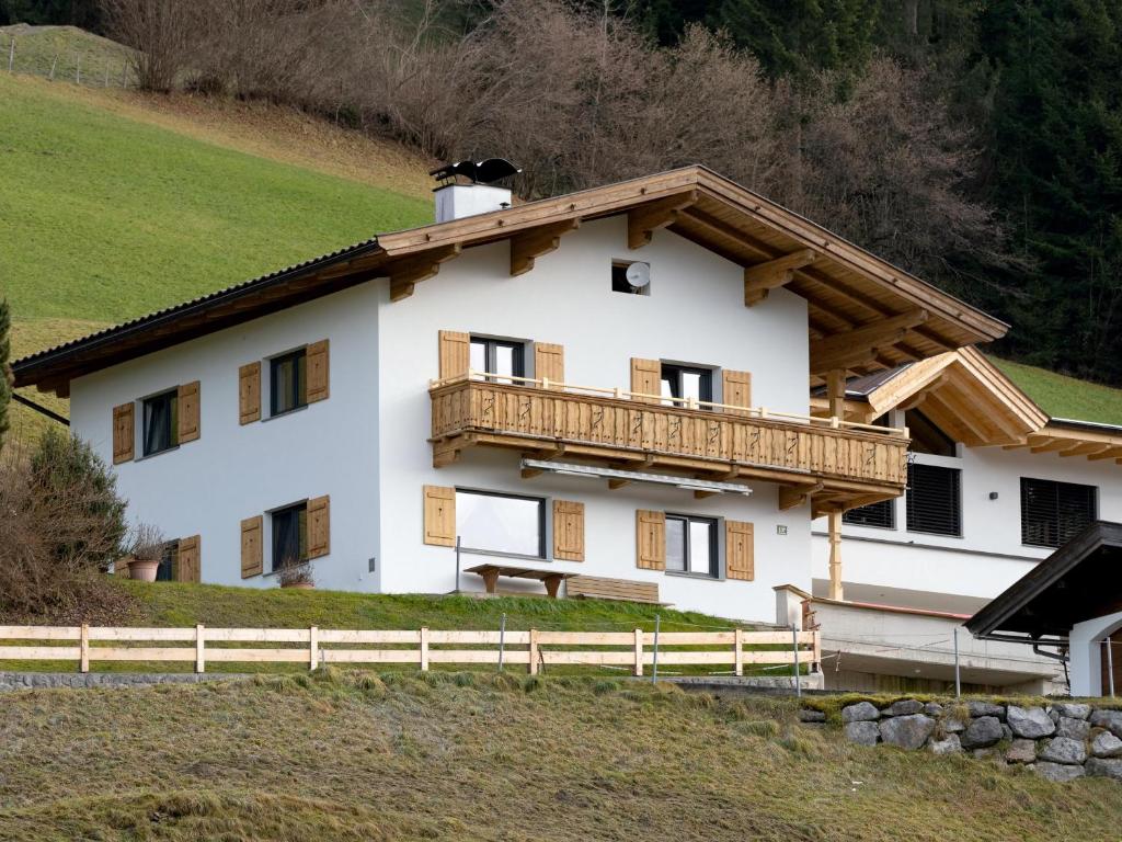a large white house with a wooden balcony at Haus Gletscherblick in Westendorf