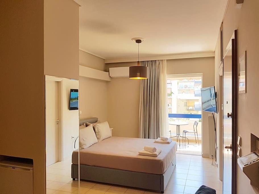 a hotel room with a bed and a balcony at Athens Campus Renovated Studio Apartment @ Ilisia in Athens
