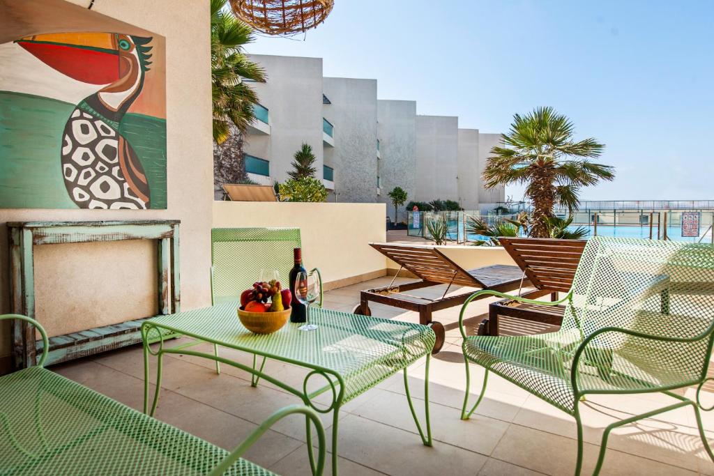 a patio with chairs and tables on a balcony at Cotillo Ocean Waves 1 in Cotillo