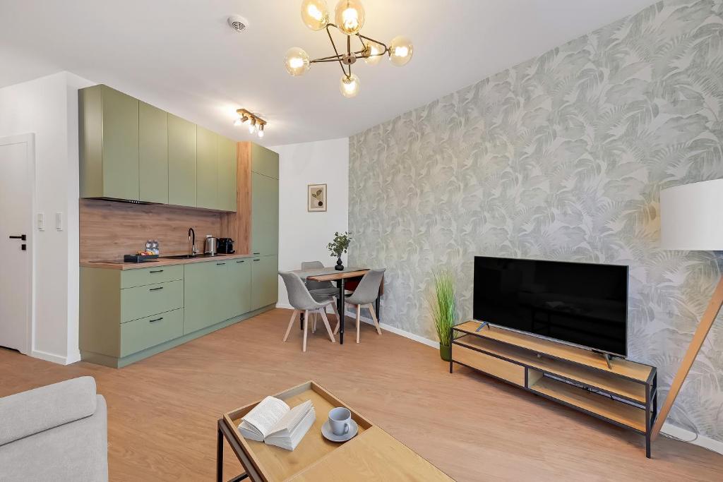 a living room with a flat screen tv and a table at Downtown Apartments Śląska 12 in Gdańsk