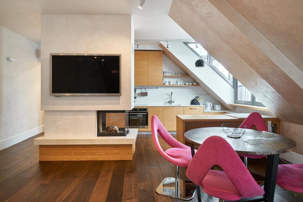 een woonkamer met een tafel en roze stoelen bij EMI Apartment in Rīga
