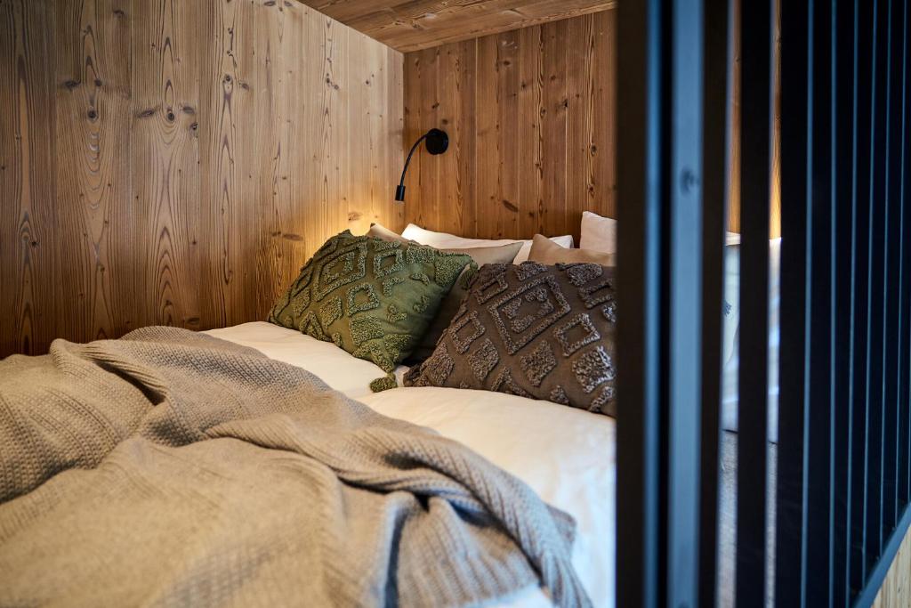 a bed in a room with a wooden wall at Aparthotel Chalina in Leutasch