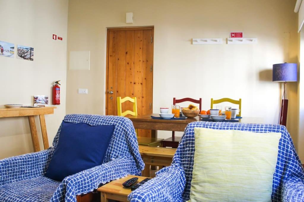 uma sala de estar com duas cadeiras e uma mesa em Casa da Areia na Nazaré