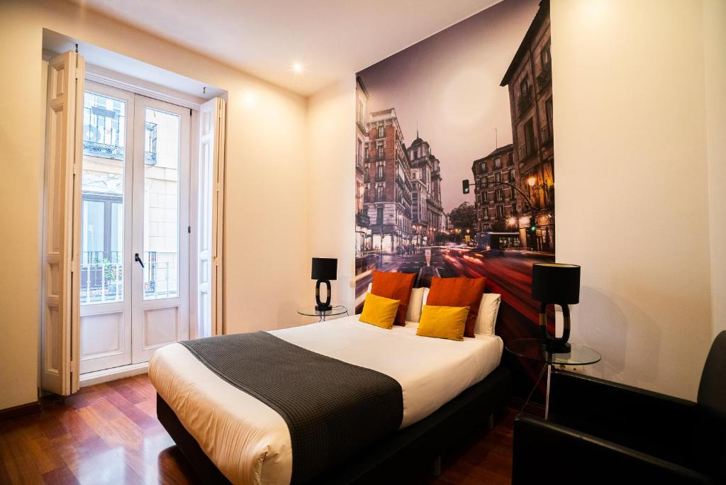 1 dormitorio con 1 cama grande y una pintura en la pared en Smartr Madrid Atocha, en Madrid