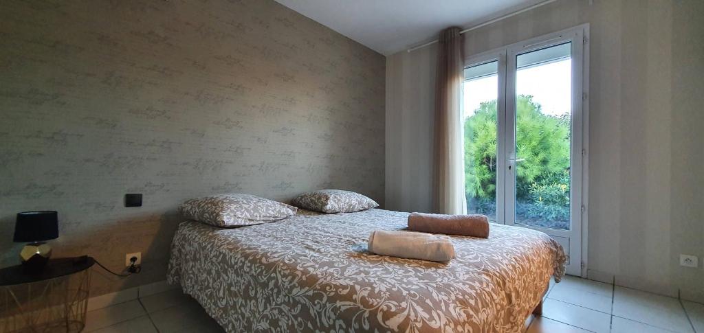 a bedroom with a bed with pillows and a window at La Villa de l'Olivier piscine privée et parking in Carcassonne