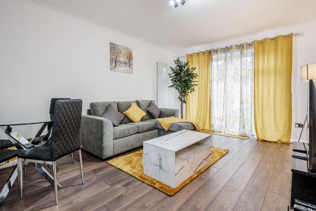 uma sala de estar com um sofá e uma mesa em Lovely House in Dagenham / Barking with free parking, WiFi & Garden em Dagenham