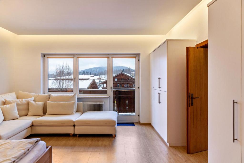 a living room with a couch and a large window at Haus Excelsior Top 14 in Seefeld in Tirol
