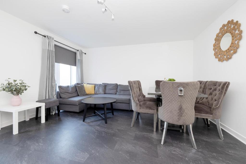 a living room with a couch and a table and chairs at Stylish House with Garden and Parking in Glasgow