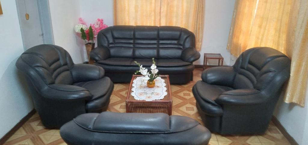 uma sala de estar com cadeiras de couro e uma mesa em Paradise Resting Home em Réunion