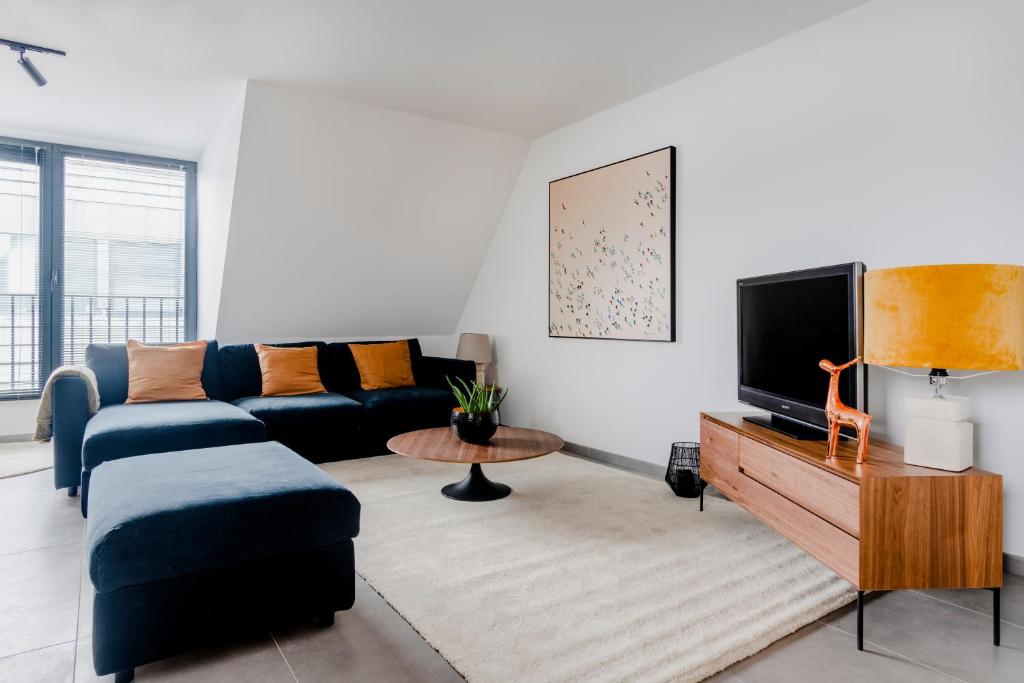 ein Wohnzimmer mit einem Sofa und einem TV in der Unterkunft Waterloo Design Residence in Waterloo